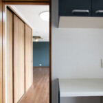 独立した一部屋のキッチンとリビングを結ぶ導線には、壁一面の収納があります。